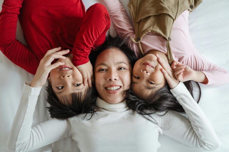 Asian mom with two children lying down together looking up